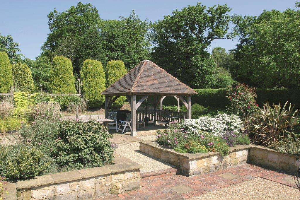 an oak framed gazebo in a garden