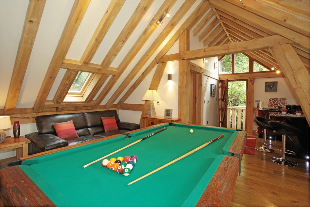 "man cave" interior with sofa and pool table, bar at the rear.