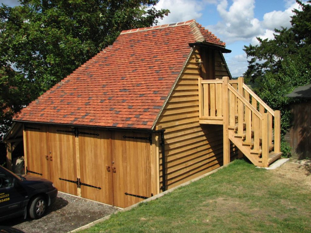 An oak framed double garage with a room above on an upper floor, accessible by exterior stairs